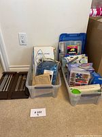 Several plastic bins and containers packed with assorted sewing and knitting supplies, including a box labeled 'Spool Stand'.