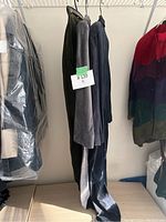 Side view of hanging blue and grey suede garments with price tag $120