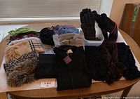 Photo showing the entire winter clothing lot including scarves, gloves, sweaters, and boots arranged on a table.