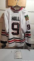 White Reebok Blackhawks #9 jersey back view with 'HULL' name and signed number