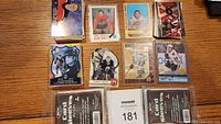 8 loose hockey trading cards and 4 packs of ACD card sleeves arranged on wooden table