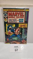 Close-up front cover photo of Marvel Double Feature #11 comic, showing colorful illustration of Captain America and text mentioning Iron Man, with comic price and date visible.