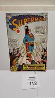Front cover of Superman #184 comic book showing Superman tied up and surrounded by people, with story title 'The Demon Under The Red Sun'.