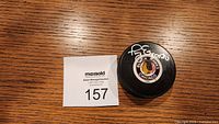 Top view of the autographed black hockey puck with Chicago Blackhawks logo and Tony Esposito signature.