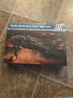 Top view of the sealed Italeri UH-60/MH-60 Black Hawk Night Raid model kit box angled on the floor.