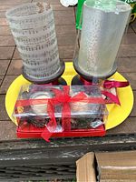 Overview of two tall candles and one package of small candles on yellow tray