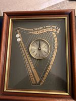 Full view of rectangular frame showing the Irish harp design with round clock face positioned centrally within the harp outline.