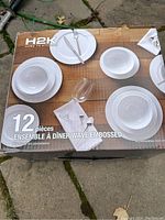 Box photo showing 12-piece H2K Wave Embossed porcelain dinner set with plates, bowls, napkins, and cutlery arrangement.