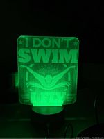 Night light glowing green, showing engraved phrase and diver graphic.