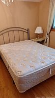 Queen mattress on matching box spring with silver metal headboard