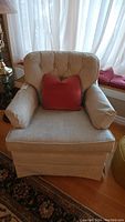 Front view of vintage cloth covered swivel rocker recliner chair with tufted backrest and red accent pillow, showcasing fabric and general condition.