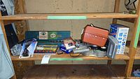 Green Thorsen toolbox, socket set, drills, saw blade container, and assorted items on wooden shelving