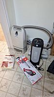 Kenmore Powermate vacuum, vacuum bags, DirtDevil cordless vacuum, Warmwave space heater on floor