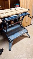 Overall front view of the Black & Decker WorkMate 400 foldable workbench showing blue metal frame, foldable legs and wooden top surface with signs of wear.