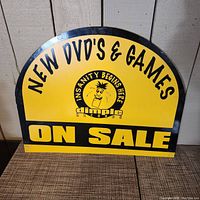 Front view of the semi-circular yellow and black Dimple Records sign with text and logo