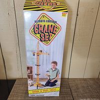 Front view of the original box with colorful label showing remote control crane set, height over 4 feet and child playing with crane image