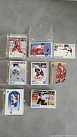 Photo of various individual hockey cards in protective cases and loose, showing players including Saku Koivu and others.