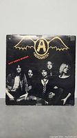 Aerosmith Get Your Wings vinyl LP album cover showing band members in black and white with gold logo.