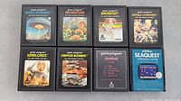 Top view of all eight Atari and Activision game cartridges showing front label artwork and titles.