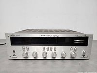 Front view showing aluminum faceplate with control knobs, tuning display and Marantz logo