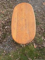 Top view showing the elongated oval wooden table top with visible wood grain.