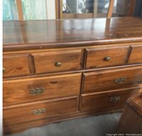 Close-up of dresser showing wood finish, drawer handles, and knobs
