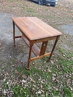 Top and side view of a small wooden kitchen table showing turned spindle legs and a lower shelf.