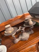 Front view of entire cast iron balance scale with multiple metal weights on the weighing plates.