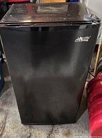 Front view of the Arctic King mini fridge, showing the black glossy finish and brand logo on the door.