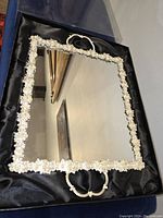 Square mirror tray with pearl and diamond-like crystal embellishments, with two handles shown in black velvet lined box, photographed from an angle