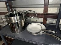 Photo showing the complete lot with Cuisinart pasta pot, strainer insert, glass lid, and two Green Pan frying pans
