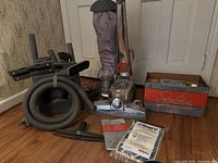 Full lot showing Kirby Sentria vacuum with fabric bag and chrome base, multiple attachments, and boxed Rug Shampoo system.