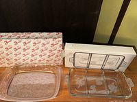 Photo showing the two crystal serving dishes positioned near their original boxes with visible brand logos and design on the boxes.