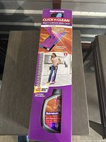 Front view of boxed Rejuvenate Click n Clean multi-surface spray mop showing product and cleaner bottle.
