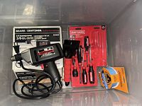 Image of Sears Craftsman electric drill, screwdriver set, Gorilla Tape and ice scraper in a plastic bin.