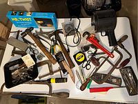 Overview of assorted hand tools and hardware on a surface