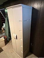 Full view of the plastic utility cabinet closed, showing side and front profile with handle and ventilation slots.