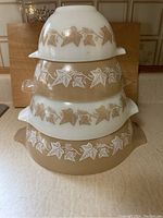 Four bowls nested and stacked alternating white and tan showing ivy leaf pattern