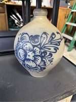 Front view of the beige round jug showing detailed blue floral design on the side.