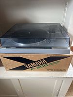 Full view of Yamaha P-200 turntable on original box, dust cover closed.