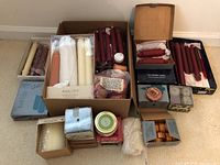 Boxes and loose candles arranged on floor showing range of candle types and packaging