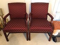 Pair of burgundy upholstered occasional chairs with wooden frames, front view