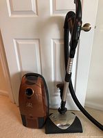 Full view of Riccar canister vacuum next to its hose and powerhead attached to handle.