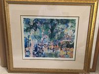 Full view of LeRoy Neiman framed art piece in gold-tone wood frame and white mat with green border, depicting outdoor dining scene.