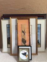 View of all seven framed artworks stacked together showing variety of sizes and frame styles.