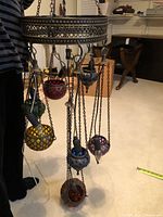 Full view of the Turkish chandelier showing the round metal frame and multi-color hanging lanterns on chains.
