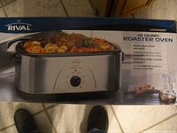 Boxed Rival 20 Quart Roaster Oven with product image showing stainless steel body and dial control