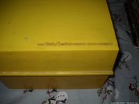 Yellow plastic recipe box with embossed Betty Crocker branding on lid.