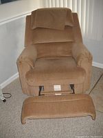 Brown La-Z-Boy recliner chair shown with footrest extended, displaying overall upholstery condition and footrest mechanism.