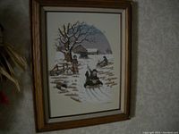Photo of framed Carson painting showing children sledding near barn in winter